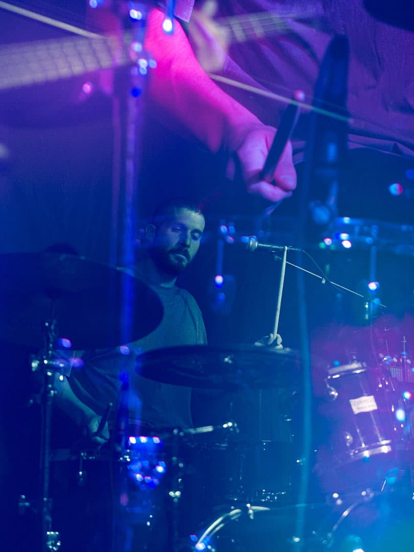 SAYST batterista ripreso da dietro durante un momento di grande energia sul palco